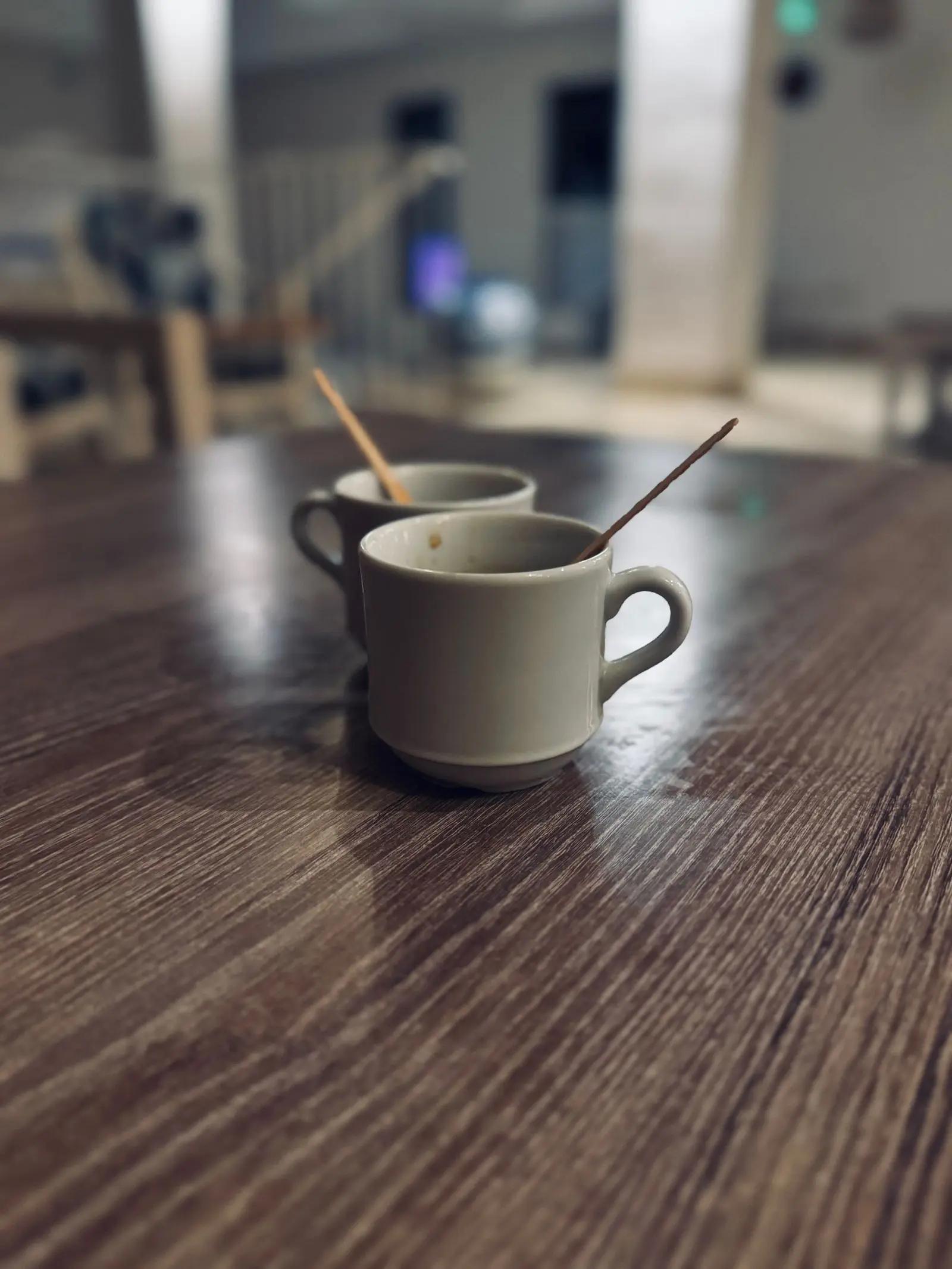 Two cups of coffee on a dark wooden table