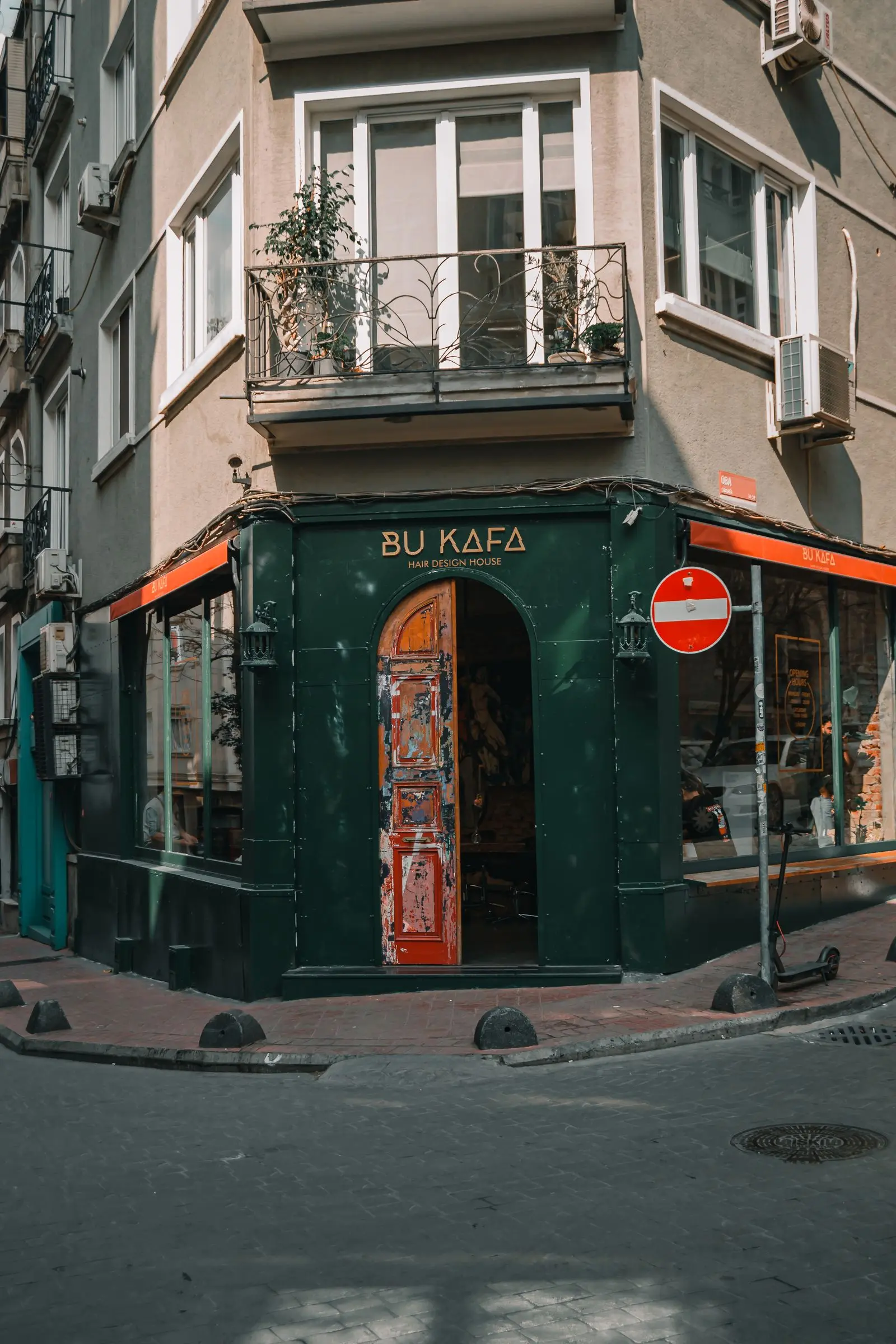 A green café storefront seen from the pavement